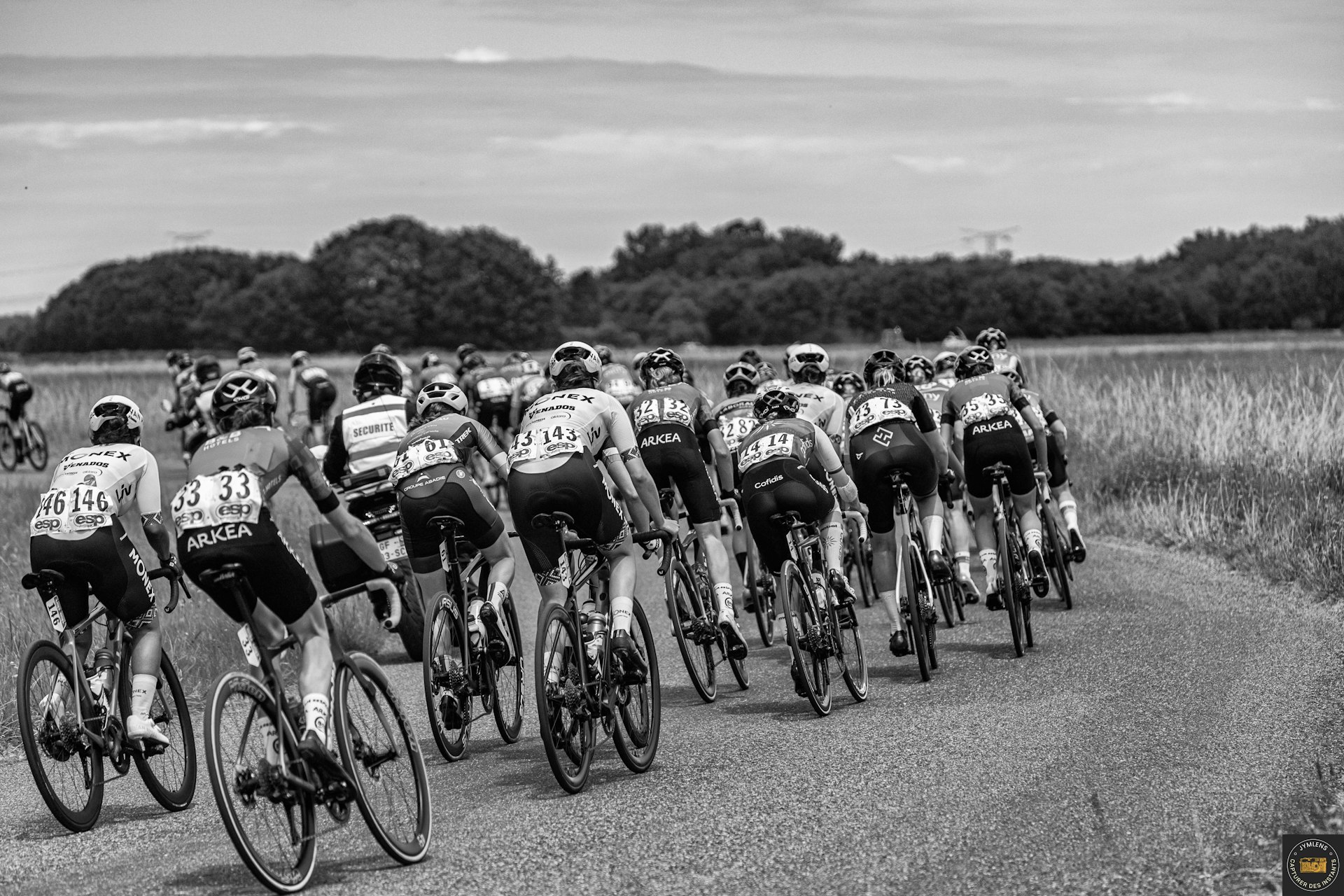 A group of people riding bikes down a road